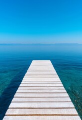 Obraz premium Tranquil Beach Jetty Stretching Into Calm Turquoise Waters Under Clear Blue Sky