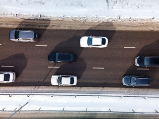  View from the height of the highway clogged with cars. A big long traffic jam of cars moving to...