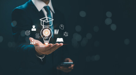 Online education course concept or e-learning ,Businessman hand show light bulb icon and virtual graduation cap. Internet training about education, knowledge for creativity and learning new things