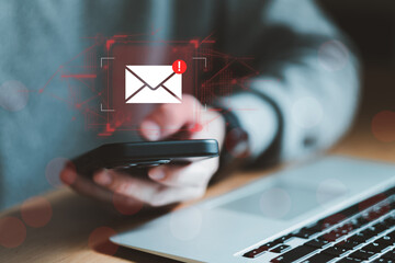 Business man using smartphone and computer that show warning sign after got attack phishing email...
