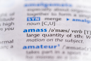 Amass word in a dictionary. Selective focus, close up.