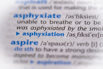 Asphyxiation word in a dictionary. Selective focus, close up.