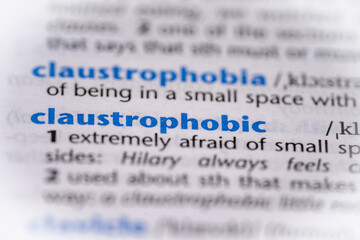 Claustrophobic word in a dictionary. Selective focus, close up.