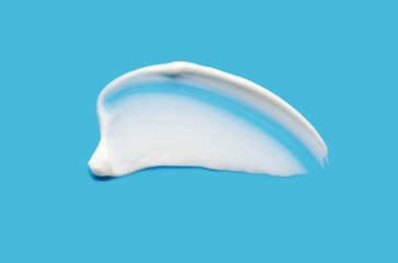 A sample of white cosmetic moisturizer on a blue background