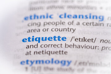 Etiquette word in a dictionary. Selective focus, close up.