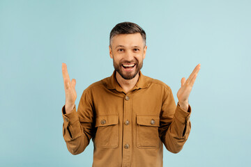 Wow. Overjoyed man with open mouth gesturing in amazement and looking at camera, posing standing...