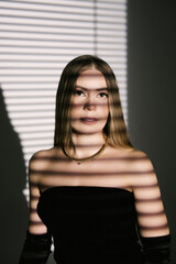 Portrait of a woman in a studio with professional lighting in a smart dress with gloves
