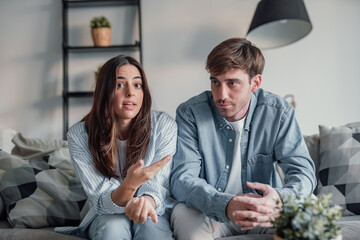 Young couple arguing and talking to the camera in videocall conference with specialist about relationship problems difficulties. Sad and angry man and woman arguing indoor debating future