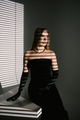 Portrait of a woman in a studio with professional lighting in a smart dress with gloves