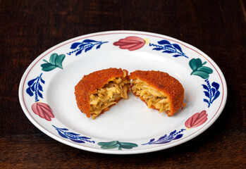 Halved bamischijf on the plate, dutch snack consisting of breaded and deep fried bami noodles