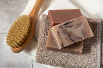 Organic natural solid soap bars, cotton towel and massage brush top view. Morning face wash ritual concept