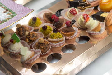 Colorful assortment of delicate pastries displayed on a tray at a festive gathering in a quaint bakery