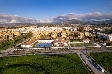 Fototapeta premium Urban development with International College school in the foreground in bathing and tourist Costa del Sol Spanish Mediterranean city San Pedro de Alcantara