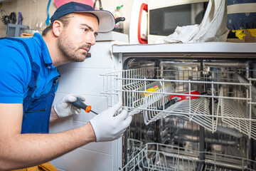 One expert repairman fixing a broken dishwasher in the kitchen