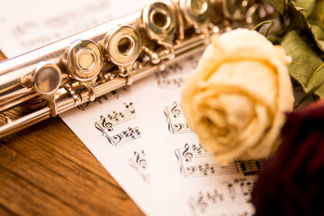 Naklejka premium a flute and dried roses on music