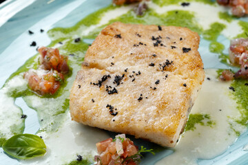 The fish dish is fried fillets with tomatoes. Restaurant dish, high-class presentation. Macro