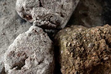 An exquisite and artistic dessert presentation featuring elegant chocolate and fine powdered sugar. Decorated with natural stones. Macro top view