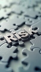 Close up photo puzzle pieces with word Risk. Puzzle concept for risk management in business. Image shows word Risk formed by assembled puzzle pieces. Represents complex nature of risk management,