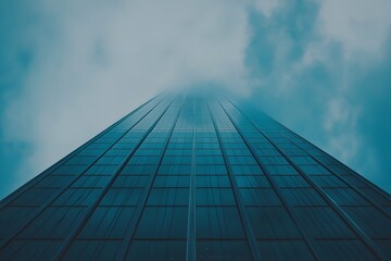 Fototapeta premium Modern Glass Skyscraper Reaching Towards Cloudy Sky Architectural Design Urban Landscape