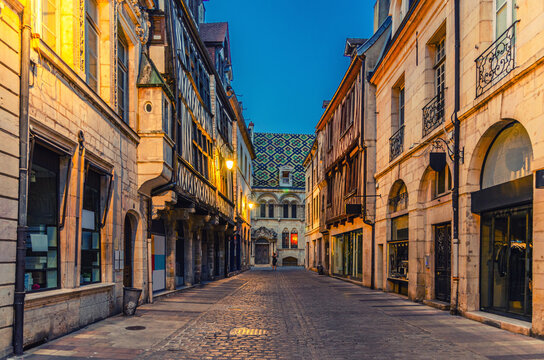 Rue Stephen Liegeard pedestrian street in Dijon city centre with stores, shops and old typical houses medieval buildings, Dijon old town on twilight evening view, Bourgogne-Franche-Comte, France - Powered by Adobe