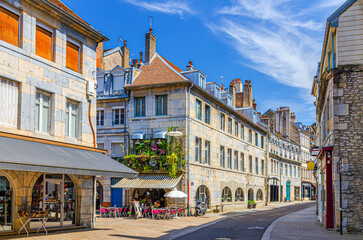 Typical street Rue des Granges in Besancon old town centre ville La boucle, Besançon city historic centre with old houses medieval buildings, street restaurant and cafe in sunny summer day, France
