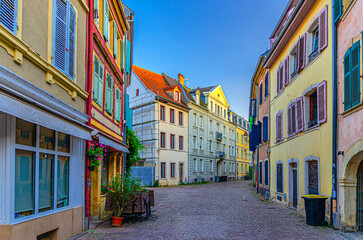Old town Mulhouse city historic centre with narrow pedestrian street, old colorful buildings, typical multicolored houses with shutter windows, Alsace Grand Est region, France