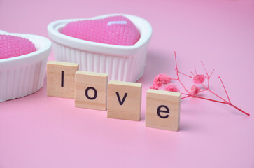 Two pink candles. Pink background. Inscription love. Valentine's Day.