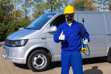 Pest control worker with spray tank showing thumbs up outdoors
