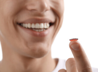 Man with color contact lens on white background, closeup. Selective focus