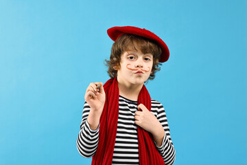 Cute boy in mime costume with brush on light blue background. Surprise party