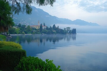 Fototapeta premium Fog blankets Lake, highlighting serene waterfront and lush vegetation at dawn