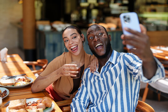 Joyful Multiracial Couple Taking Selfie at Breakfast Cafe