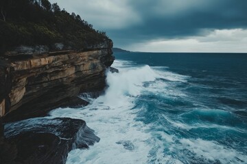 Dramatic waves hitting rugged coastal cliffs under a cloudy sky.