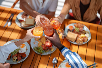 Diverse Friends Toast with Fresh Juice Over Breakfast