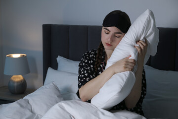 Young woman suffering from sleepwalking on bed at home