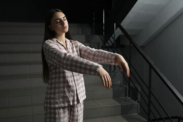 Woman suffering from sleepwalking on stairs indoors