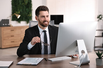 Naklejka premium Man working on computer at table in office