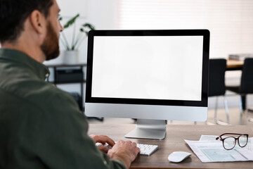Man working on computer at table in office, closeup