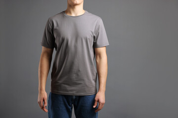 Man in stylish t-shirt on grey background, closeup. Mockup for design
