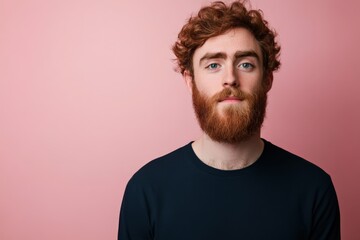 Obraz premium Portrait of a Young Man with Curly Hair and Beard Against a Pink Background