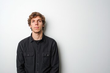 Obraz premium Young Man with Casual Style Posing Against a Plain Background