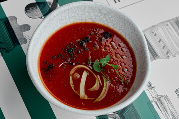 Vibrant Tomato Soup Garnished with Herbs and Oil Drizzle.