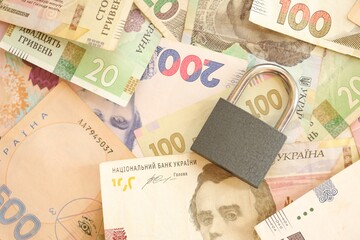 Many ukrainian money bills and small black padlock.