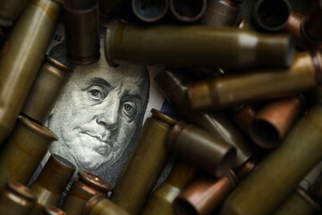 Conceptual image of US presidents face surrounded by many used rifle cartridges. Details of US...