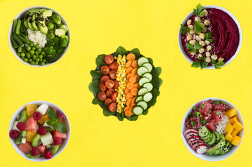 Chopped vegetables, fruit salade, beetroot smoothie and poke - food in the bowls on  a yellow background. Top view.