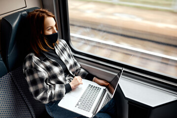 Woman on Train Typing on Laptop.