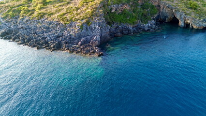 Cinematic aerial view from top about a white little boat running in a hypnotic blue colored sea