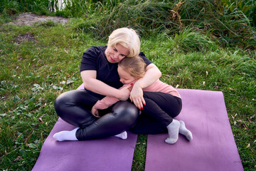 Mother and daughter sharing a comforting hug outdoors in a riverside