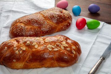 Easter sweet bread, two tsoureki braids and colorful Easter eggs on the table