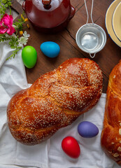 Easter sweet bread, two tsoureki braids and colorful Easter eggs on the table